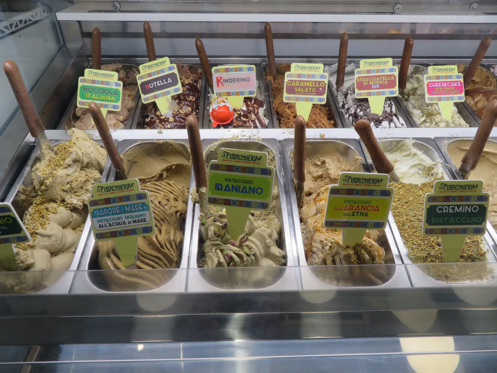 Behälter mit handwerklichem italienischem Gelato im Schaufenster, cremig und in natürlichen Farben