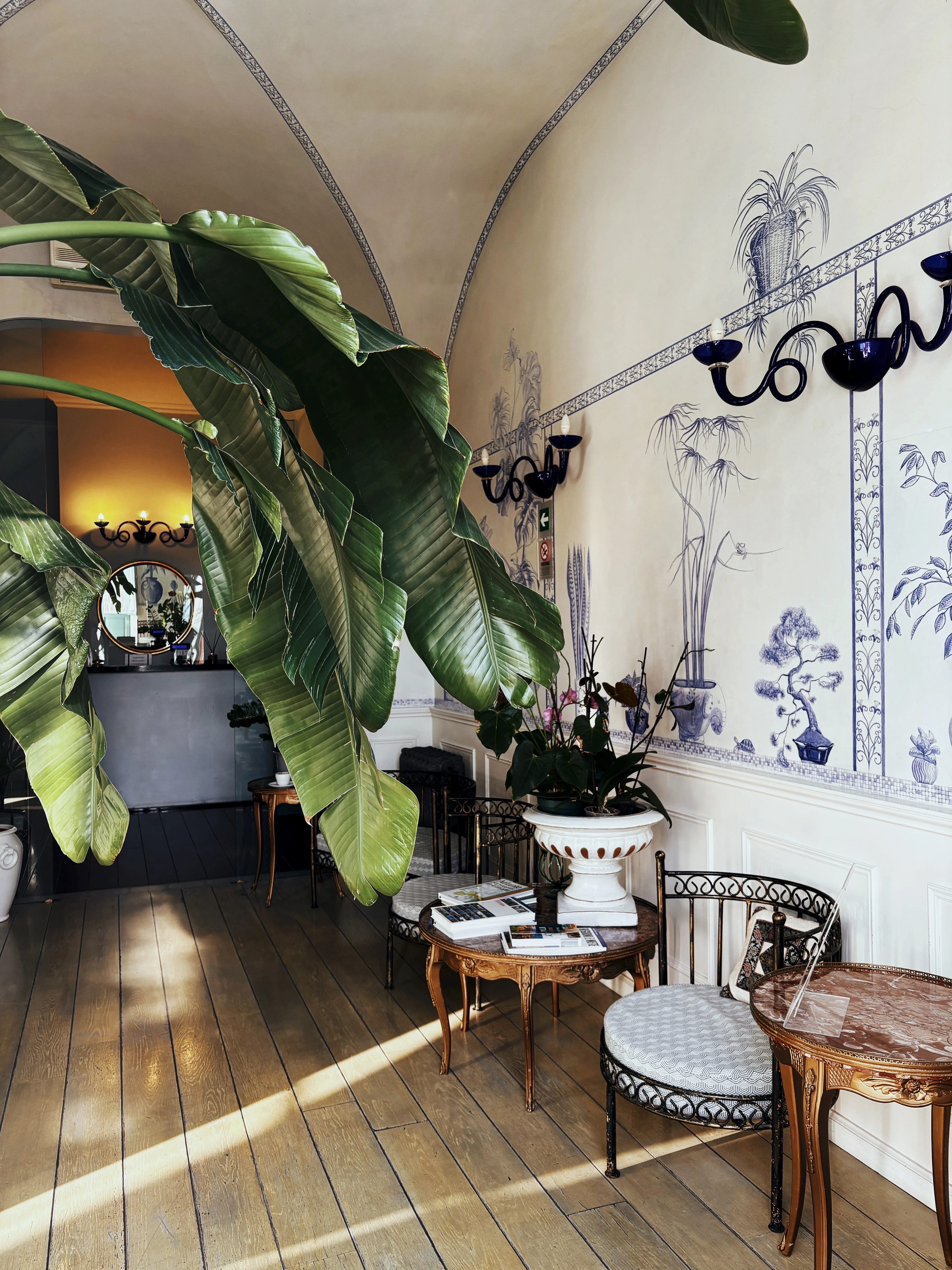 Reception del Lilium Boutique Hotel Roma — sala con affreschi botanici e piante tropicali